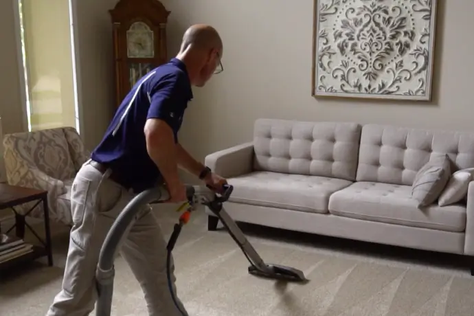 A technician operating a carpet cleaning machine in a Michigan residence
