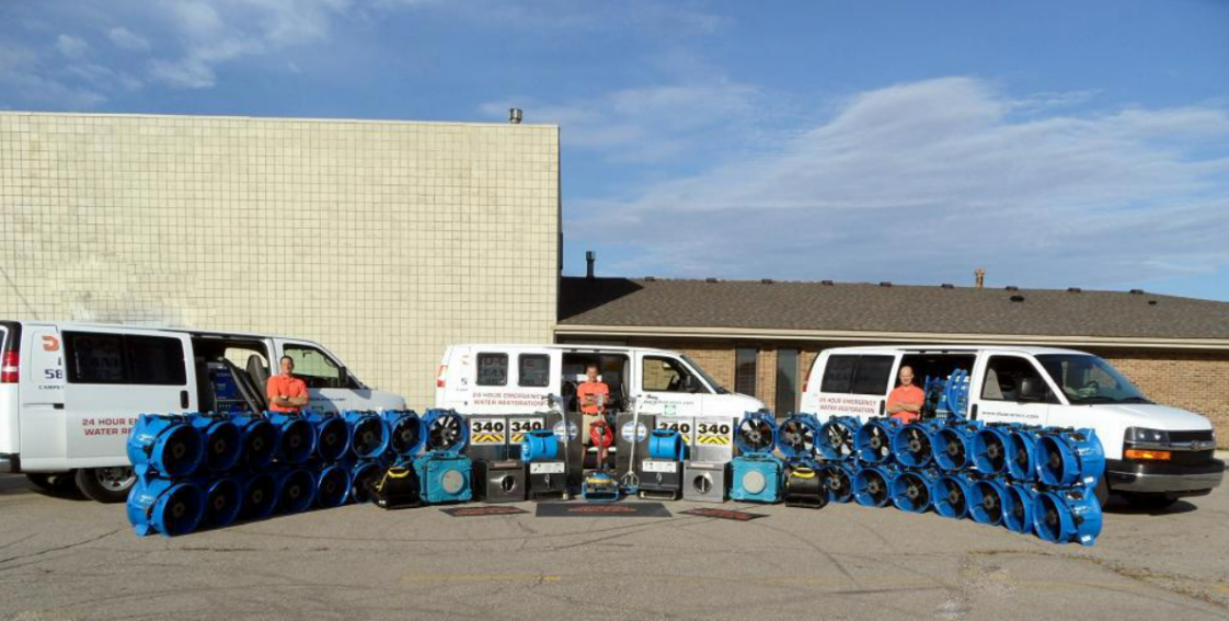 Water restoration service showcasing equipment and vans for emergency water damage repair.
